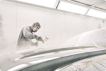 a man painitng a car