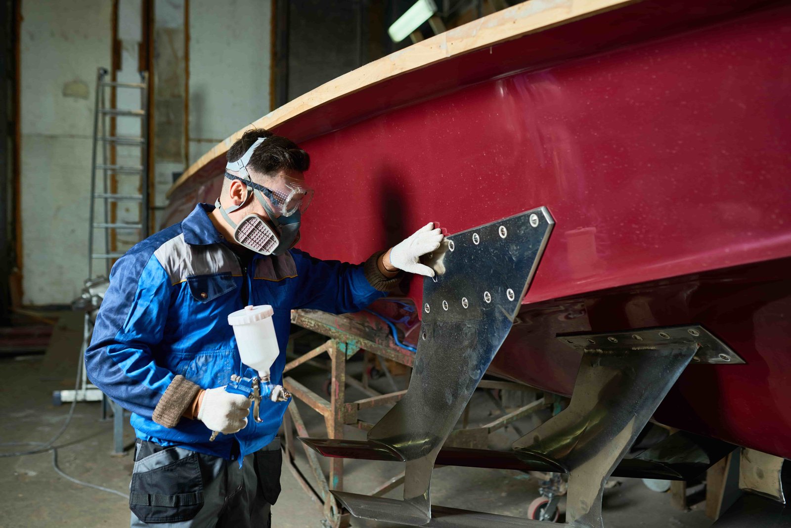 a man in uniform painting a boat